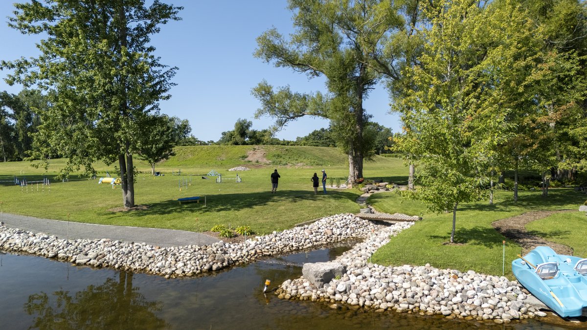 The completed stone-lined creek mouth curving out into the bay