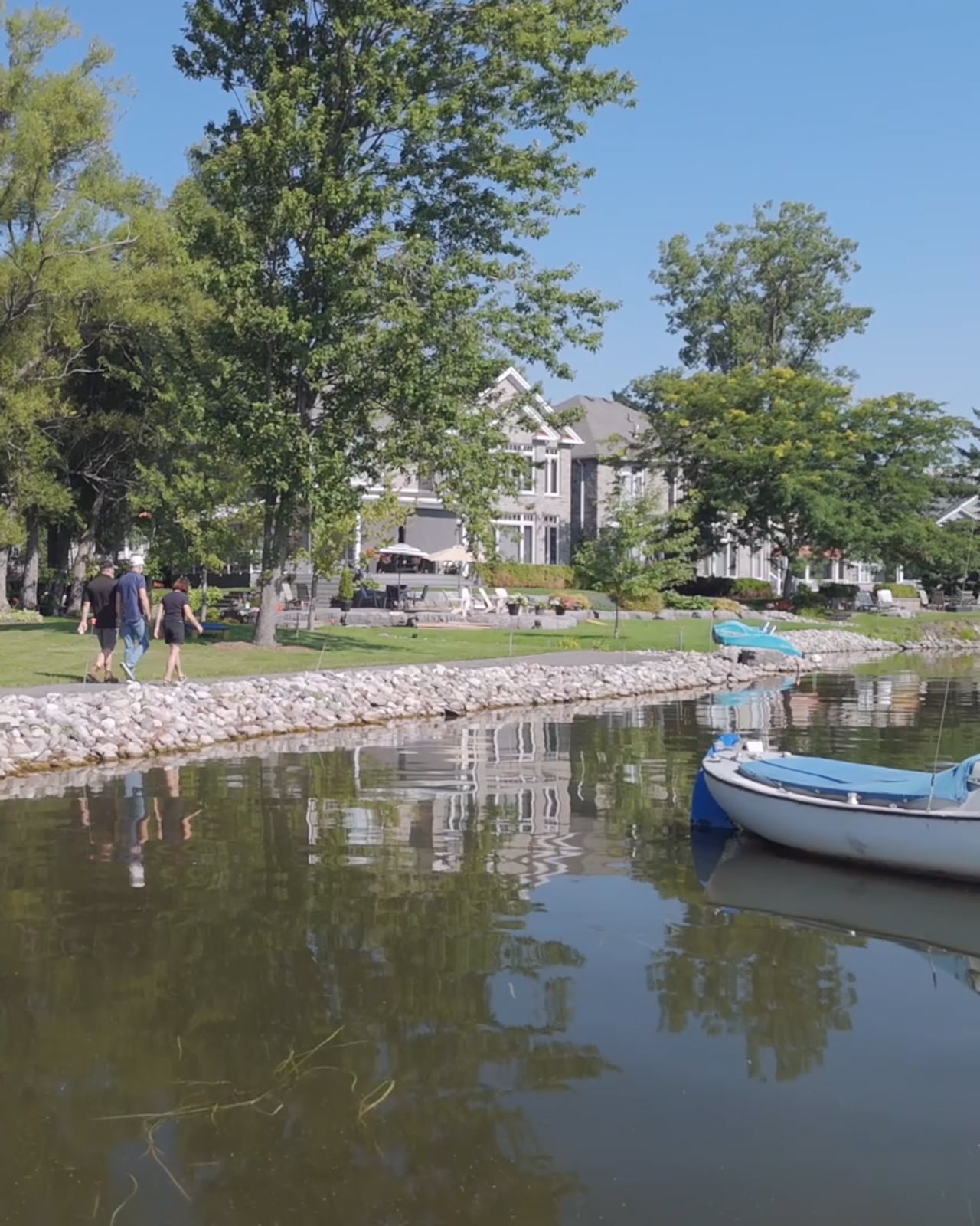 Shoreline path and stonework along the Bay of Quinte with a boat moored offshore